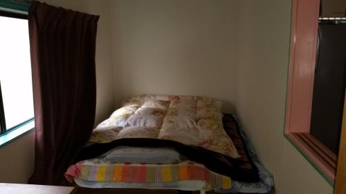 a bed sitting in a corner of a room at "Cherry House" is Direct to Narita,Haneda AP, Disney, Asakusa, Skytree Tower, Tokyo in Matsudo