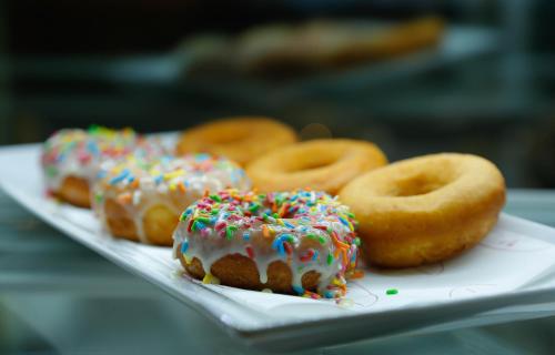 a plate of donuts with frosting and sprinkles at Sarova Woodlands Hotel and Spa in Nakuru