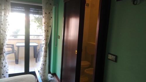 a room with a door open to a balcony with a table at Agave in Reggio Calabria
