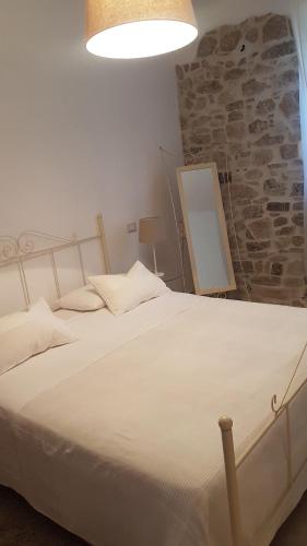 a white bed in a room with a stone wall at Il Palazzetto dei Briganti in Guardiaregia