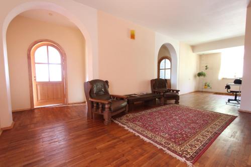 a living room with a desk and chairs and a rug at Forest B&B in Krāslava