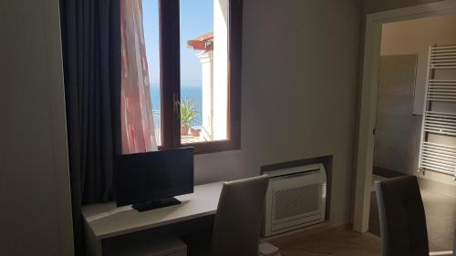 a desk with a computer monitor and a window at B&B Terrazze Chiaramontane in Marina di Palma