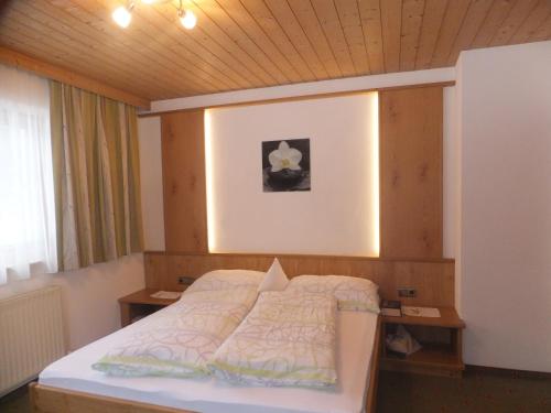 トゥクスにあるHaus Feldbründlの木製の天井が特徴のベッドルーム1室(ベッド1台付)