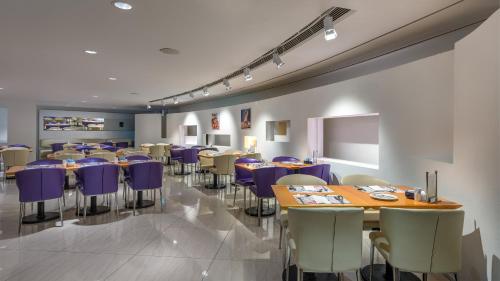 a dining room with tables and purple chairs at Regal Airport Hotel in Hong Kong