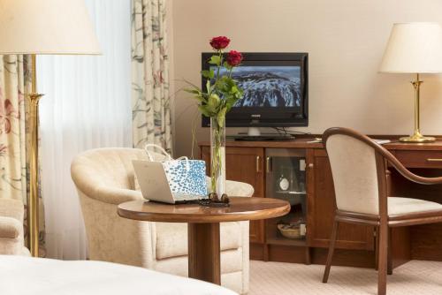 a hotel room with a table with a laptop on it at Maritim Hotel Bad Wildungen in Bad Wildungen