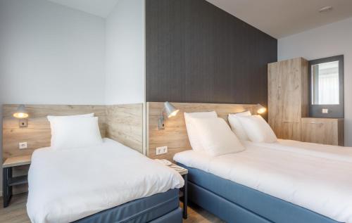 a hotel room with two beds and a desk at Joy Hotel in Amsterdam