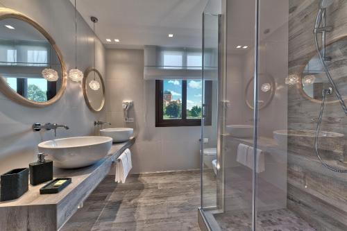 łazienka z 2 umywalkami i 2 lustrami w obiekcie Hotel Petrarca Terme w mieście Montegrotto Terme