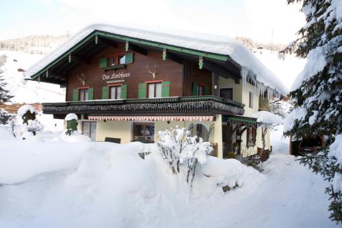 a building covered in snow with trees in front of it at Das Landhaus in Gerlos