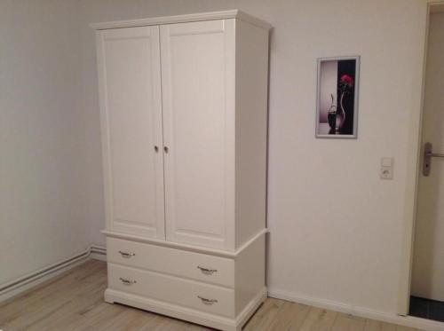 a large white cabinet in a room at Haus Irma in Zingst
