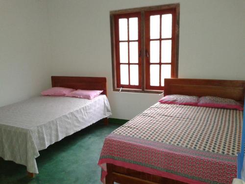 a bedroom with two beds and a window at Horton Mountain in Ohiya