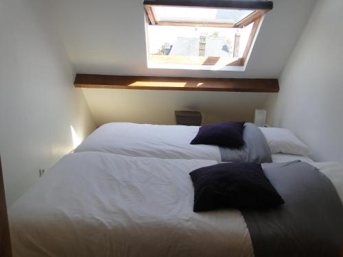 une chambre avec deux lits et une fenêtre dans l'établissement Cote Port, au Crotoy