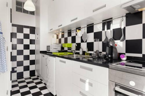 a kitchen with black and white checkered wall at Rendez Vous Porto in Porto