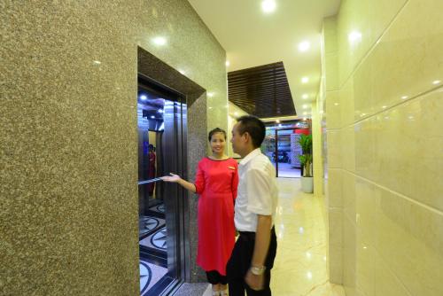 a man and a woman standing in a hallway at Blue Hanoi Inn Luxury Hotel in Hanoi