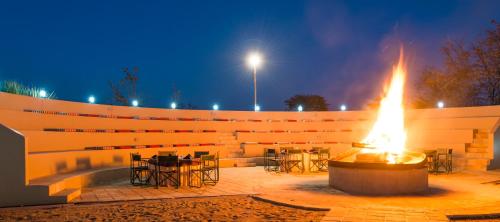 a fire pit in a courtyard with tables and chairs at The David Livingstone Safari Lodge & Spa in Livingstone