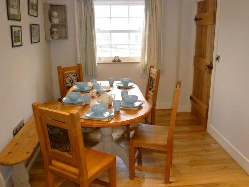 ein Esszimmer mit einem Holztisch und Stühlen in der Unterkunft Jasmine Cottage in Llangollen