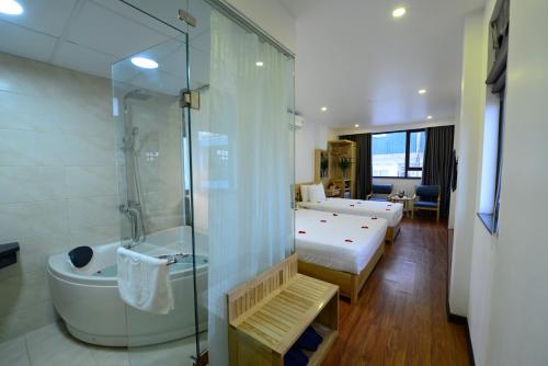 河內的住宿－Blue Hanoi Inn Luxury Hotel，酒店客房配有一张床、淋浴和浴缸。