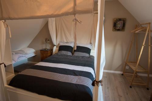 a bedroom with a canopy bed in a attic at La plage a pied in Plouhinec