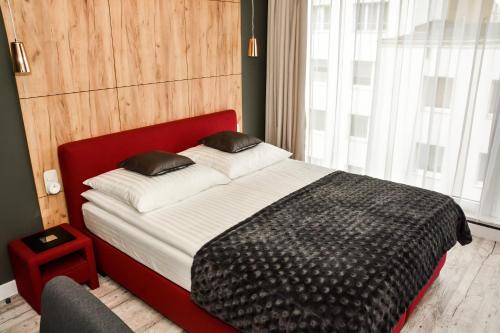 1 cama con cabecero rojo en una habitación en Apartament 34 Gdynia KLIMATYZOWANY, en Gdynia