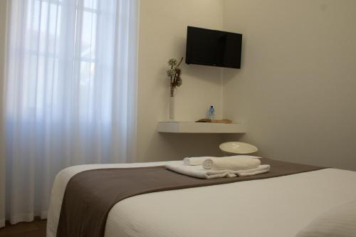 a bedroom with a bed with a tv on the wall at La Corte sul Naviglio in Boffalora sopra Ticino
