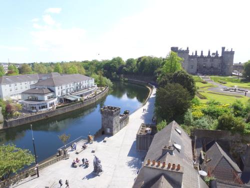 a view of a river with a castle in the background at Kilkenny River Court Hotel in Kilkenny