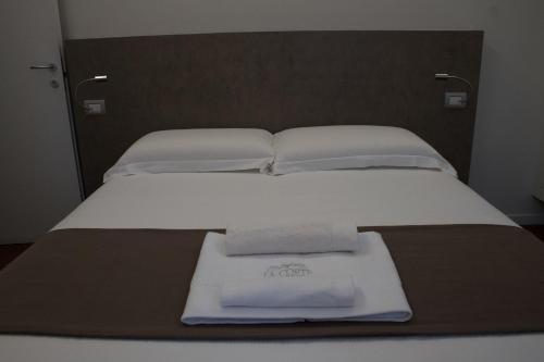 a bed with two folded towels on top of it at La Corte sul Naviglio in Boffalora sopra Ticino