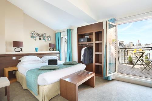 a hotel room with a bed and a large window at Le Grand H&ocirc;tel de Normandie in Paris