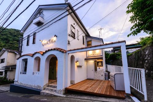 a white house with a wooden deck at Guest Villa Hakone Yumoto 201 in Hakone