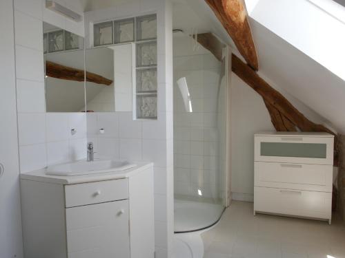 Baño blanco con lavabo y bañera en Gîtes de la Grande Ferme, en Avernes