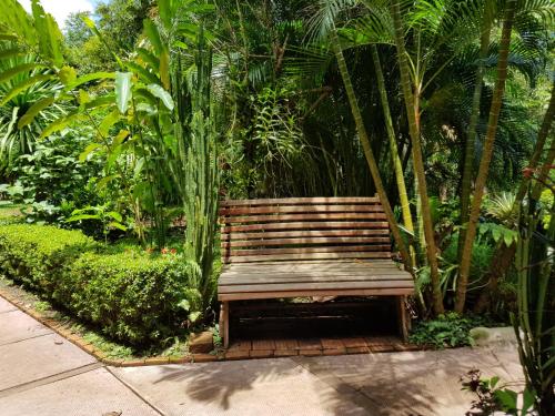 a wooden bench sitting in the middle of a garden at Kingfisher Ecolodge in Ban Kian-Ngông