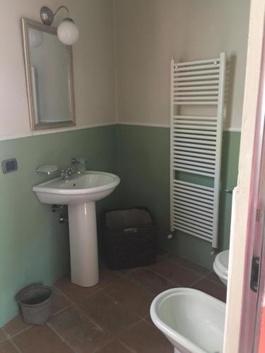 a bathroom with a sink and a toilet and a mirror at B&B San Martino in Mede