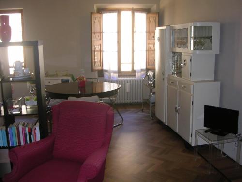 - un salon avec une chaise rouge et une table dans l'établissement Accogliente bilocale centro storico, à Arezzo