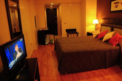 a bedroom with a bed and a flat screen tv at Gran Hotel Continental in Mar del Plata
