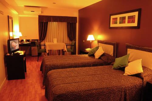 a hotel room with two beds and a table at Gran Hotel Continental in Mar del Plata
