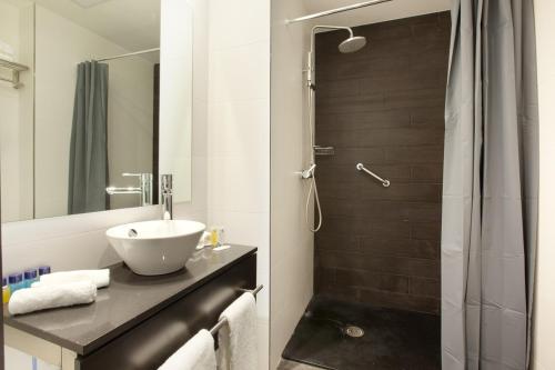 uma casa de banho com um lavatório e um chuveiro em Dalia Ramblas em Barcelona