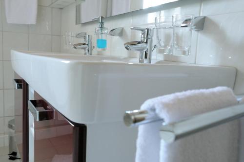 a white sink in a bathroom with a towel at Zur Alten Schmiede in Naumburg