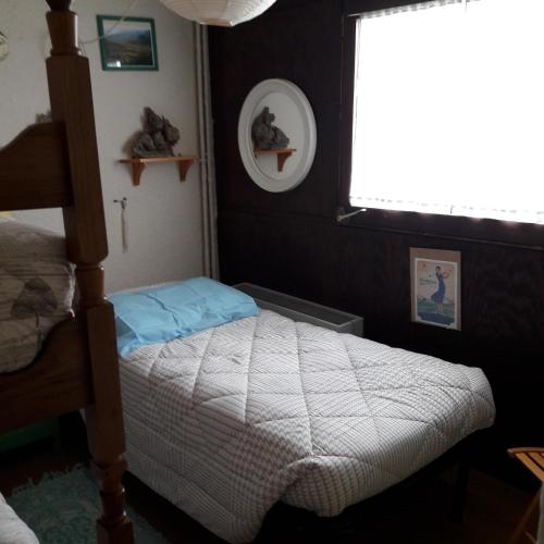 une petite chambre avec un lit et une fenêtre dans l'établissement Renardière 3, à Montgenèvre