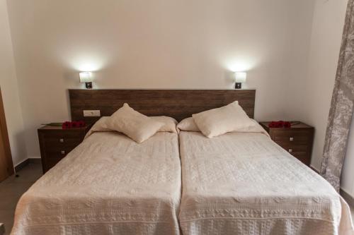 1 dormitorio con 2 camas y 2 lámparas en la pared en Hostal Soledao, en Los Baños