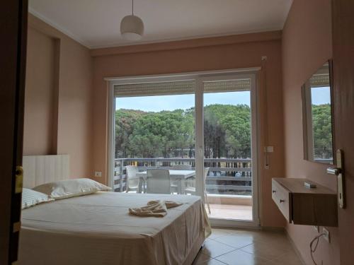 a bedroom with a bed and a large window at EME APARTMENTS - Kompleksi Lura 2 Gjiri i Lalzit in Draç