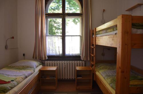 a bedroom with two bunk beds and a window at Pension zur Wartburg in Görlitz