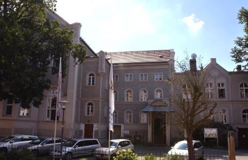 a large building with cars parked in front of it at Pension zur Wartburg in Görlitz