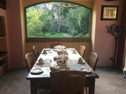 a dining room with a table and a large window at B&B San Martino in Mede