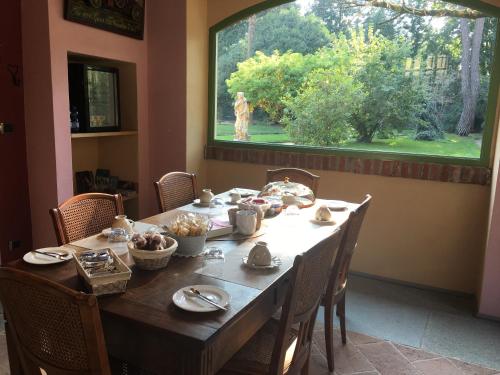 a dining room table with a dog in the window at B&B San Martino in Mede