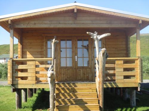 a log cabin with a porch and a door at Fálki cottages in Þórshöfn