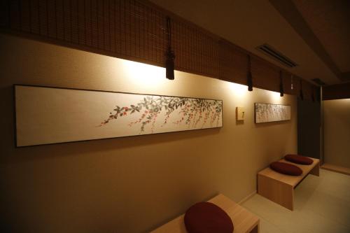 a room with two benches and a painting on the wall at Onyado Nono Nara Natural Hot Spring in Nara