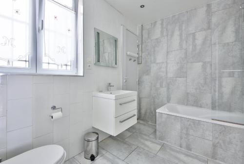 une salle de bain avec une baignoire, un lavabo et des toilettes dans l'établissement Two-Bedroom Apartment Champs-Elysées, à Paris