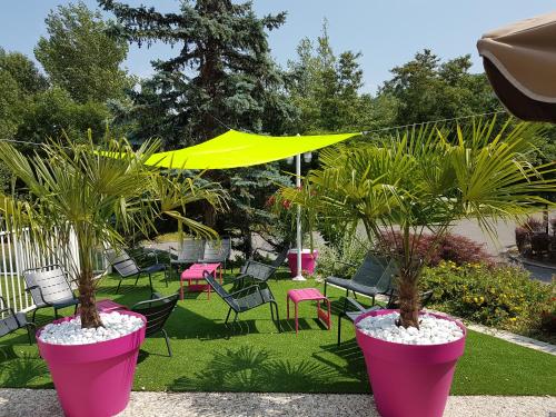 two large pink pots with palm trees in a yard at Mercure Annemasse Porte De Genève in Gaillard