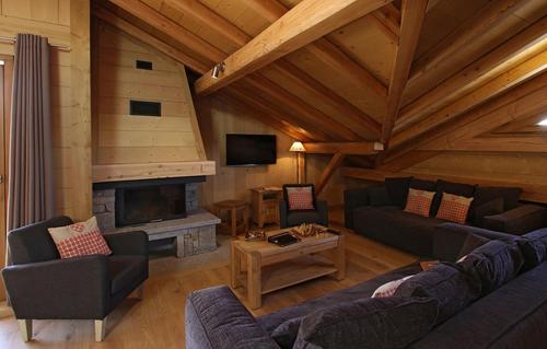 - un salon avec des canapés et une cheminée dans une cabine dans l'établissement Odalys Chalet Levanna Orientale, à Les Deux Alpes