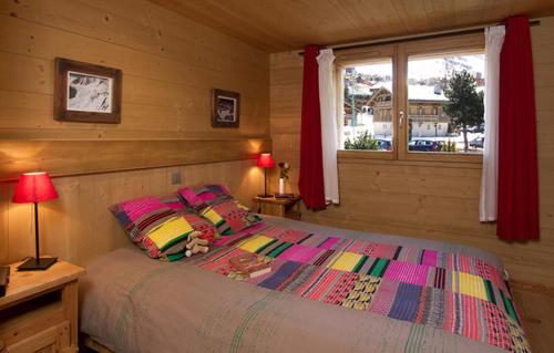 1 dormitorio con cama y ventana en Odalys Chalet Levanna Orientale, en Les Deux Alpes