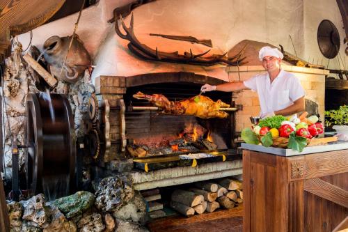 a man standing in front of a oven with a turkey at Spa Hotel Rich in Velingrad