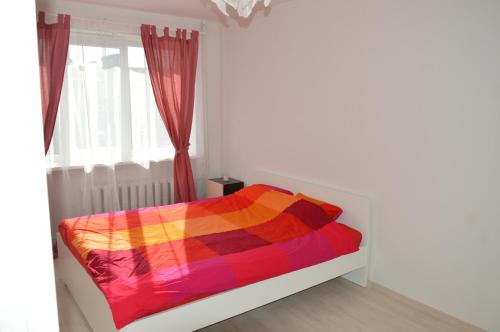 a bedroom with a bed with a colorful blanket at Apartment with Sea View in Liepāja
